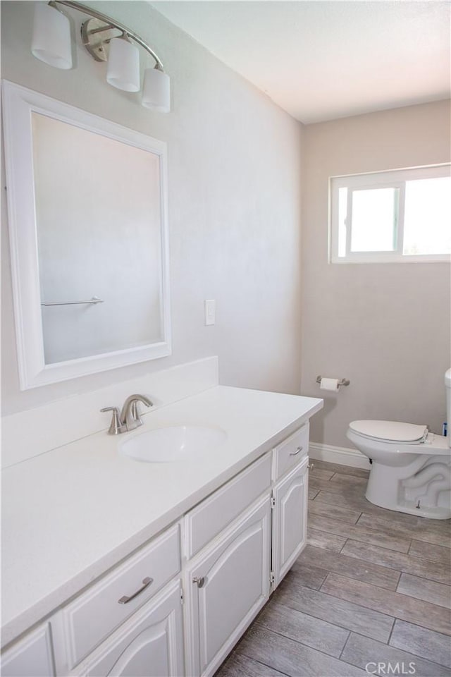 17471 Reed St, Fontana, CA 92336 - bathroom with vanity, toilet, wood finished floors, and baseboards