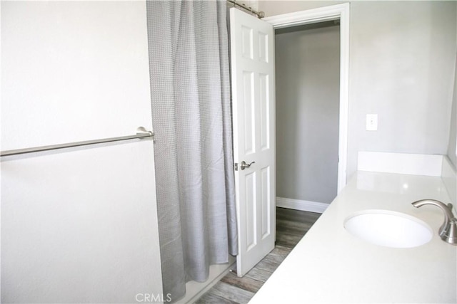 17471 Reed St, Fontana, CA 92336 - bathroom with wood finished floors, a shower with curtain, vanity, and baseboards