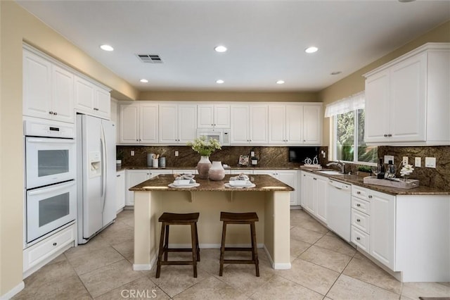 33850 Sattui St, Temecula, CA 92592 - kitchen with white appliances, a center island, white cabinets, and recessed lighting