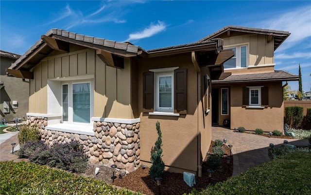 33850 Sattui St, Temecula, CA 92592 - view of home's exterior featuring board and batten siding, stone siding, stucco siding, and a tile roof