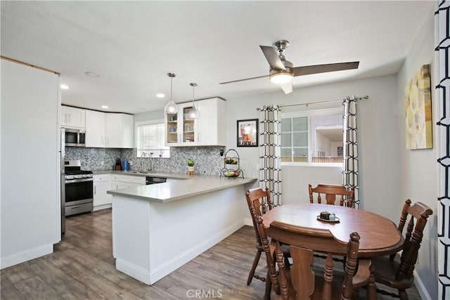 10108 Roseton Ave, Santa Fe Springs, CA 90670 - kitchen featuring stainless steel appliances, a peninsula, decorative backsplash, light countertops, and white cabinetry