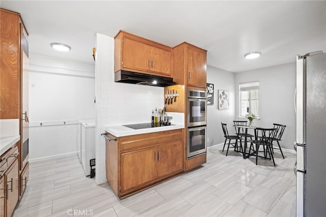 15113 Hayford St, La Mirada, CA 90638 - kitchen featuring appliances with stainless steel finishes, under cabinet range hood, washer and dryer, and light countertops