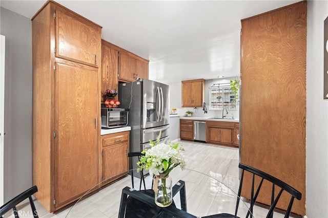 15113 Hayford St, La Mirada, CA 90638 - kitchen featuring appliances with stainless steel finishes, a sink, brown cabinets, and light countertops