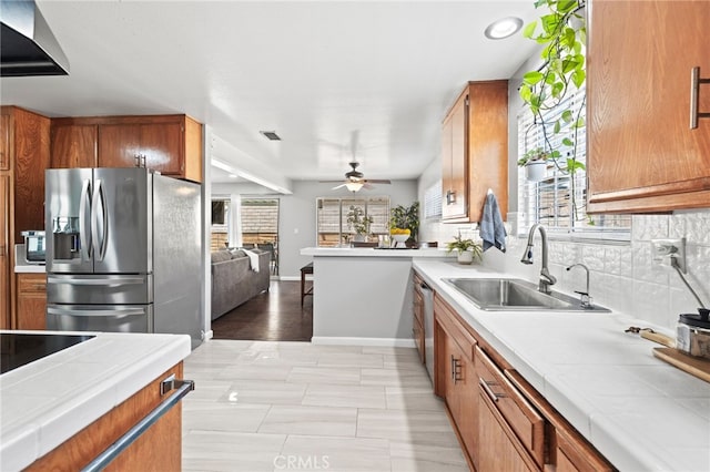 15113 Hayford St, La Mirada, CA 90638 - kitchen featuring appliances with stainless steel finishes, a sink, tile counters, and brown cabinetry