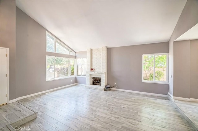 6114 Sard St, Rancho Cucamonga, CA 91701 - unfurnished living room with healthy amount of natural light, wood finished floors, a brick fireplace, baseboards, and high vaulted ceiling
