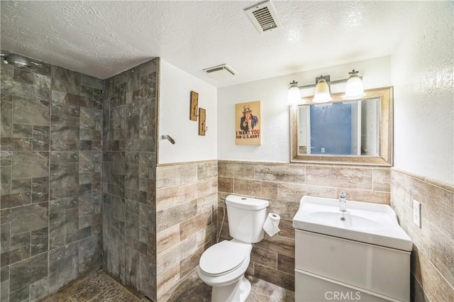 6114 Sard St, Rancho Cucamonga, CA 91701 - bathroom with vanity, toilet, tile walls, a textured ceiling, and tiled shower