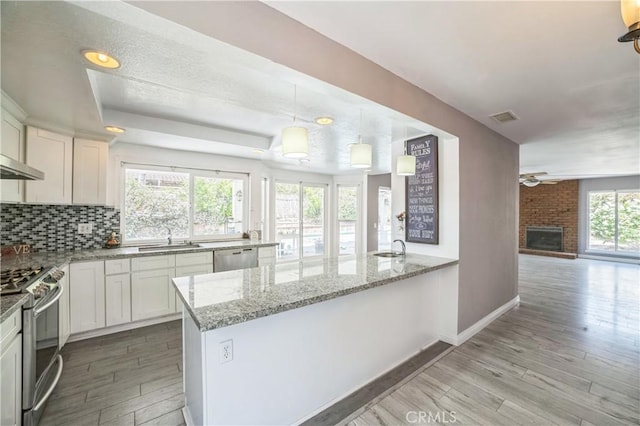 6114 Sard St, Rancho Cucamonga, CA 91701 - kitchen featuring light wood-type flooring, a ceiling fan, light stone counters, white cabinetry, and appliances with stainless steel finishes