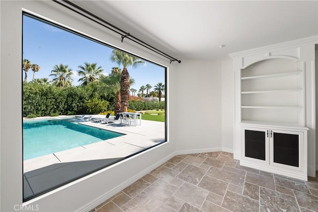 72408 Desert Dr, Rancho Mirage, CA 92270 - unfurnished living room featuring stone tile floors, built in shelves, and baseboards