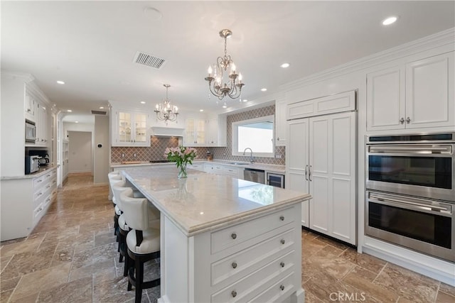 72408 Desert Dr, Rancho Mirage, CA 92270 - kitchen with appliances with stainless steel finishes, a chandelier, stone tile flooring, a sink, and recessed lighting