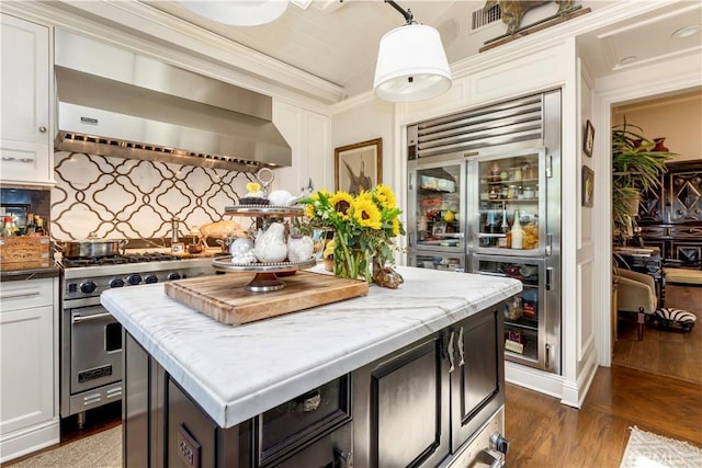 302 W Carter Ave, Sierra Madre, CA 91024 - kitchen featuring wall chimney range hood, premium appliances, a kitchen island, wood finished floors, and white cabinets