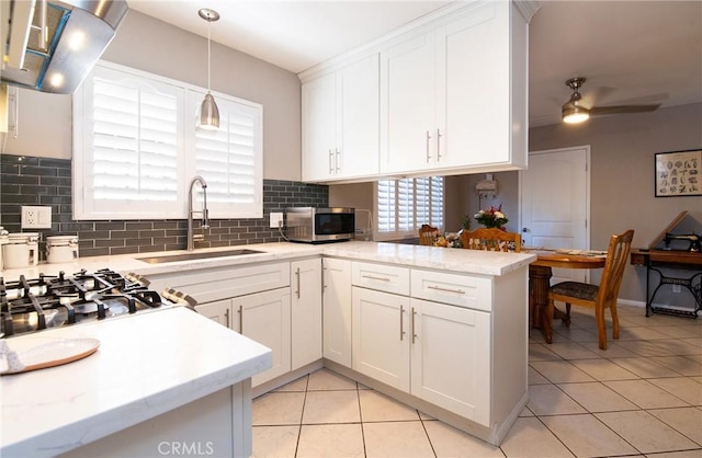 900 E Sagebank St, Carson, CA 90746 - kitchen featuring a sink, stainless steel microwave, light tile patterned flooring, backsplash, and white cabinets