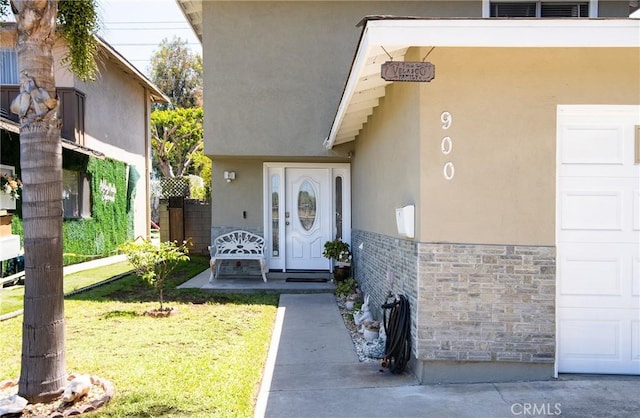 900 E Sagebank St, Carson, CA 90746 - entrance to property featuring stucco siding, stone siding, a yard, and a garage