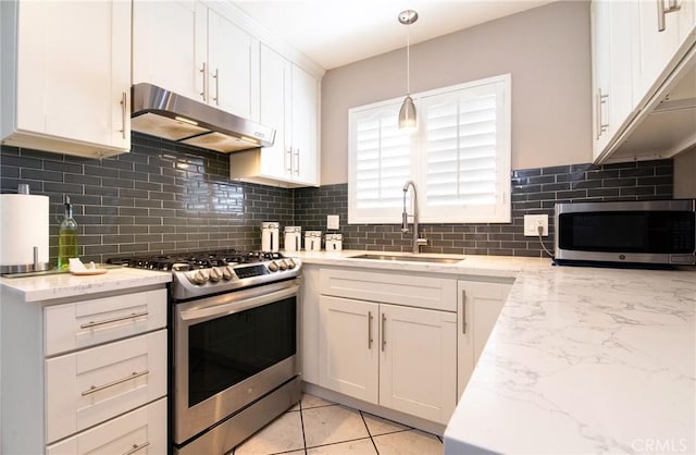 900 E Sagebank St, Carson, CA 90746 - kitchen featuring appliances with stainless steel finishes, under cabinet range hood, a sink, white cabinetry, and light stone countertops
