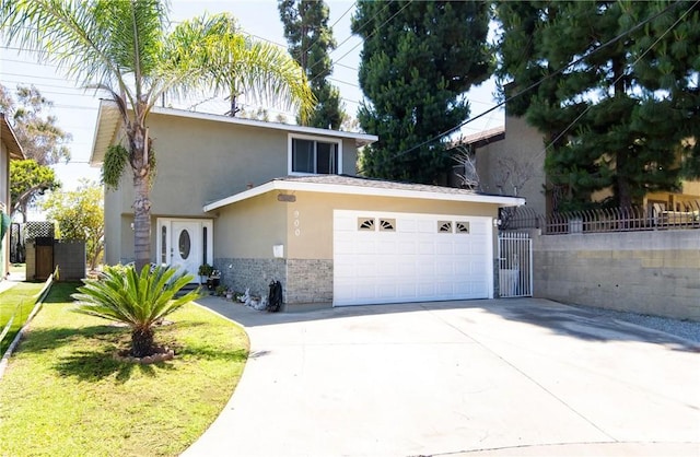 900 E Sagebank St, Carson, CA 90746 - view of front of home featuring stucco siding, stone siding, a garage, and driveway