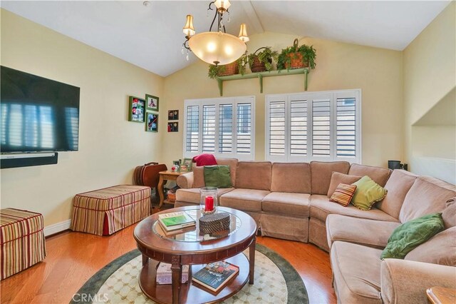 724 S Broadway Unit B, Redondo Beach, CA 90277 - living room with vaulted ceiling, wood finished floors, baseboards, and a chandelier