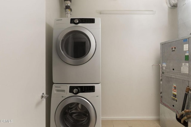 1155 S Grand Ave Unit 1403, Los Angeles, CA 90015 - laundry room featuring stacked washer and clothes dryer, baseboards, and light tile patterned floors