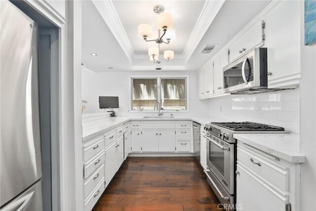 749 Canyon Crest Dr, Sierra Madre, CA 91024 - kitchen featuring stainless steel appliances, a tray ceiling, a chandelier, a sink, and crown molding