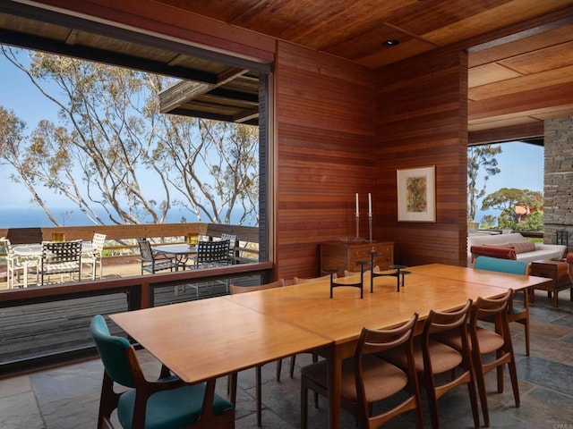 7226 Romero Dr, La Jolla, CA 92037 - dining area featuring wood ceiling, stone tile flooring, and wooden walls