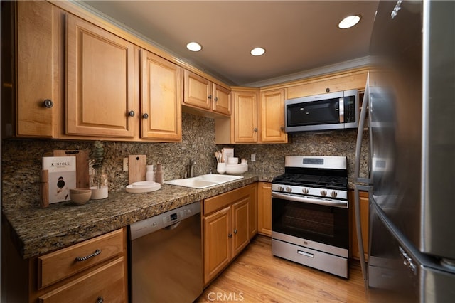 155 Oxford Unit 37, Irvine, CA 92612 - kitchen featuring appliances with stainless steel finishes, a sink, tile counters, light wood-style flooring, and backsplash