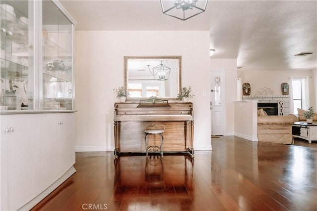 134 N American St, Ridgecrest, CA 93555 - dining room with hardwood / wood-style floors, a chandelier, baseboards, and a glass covered fireplace