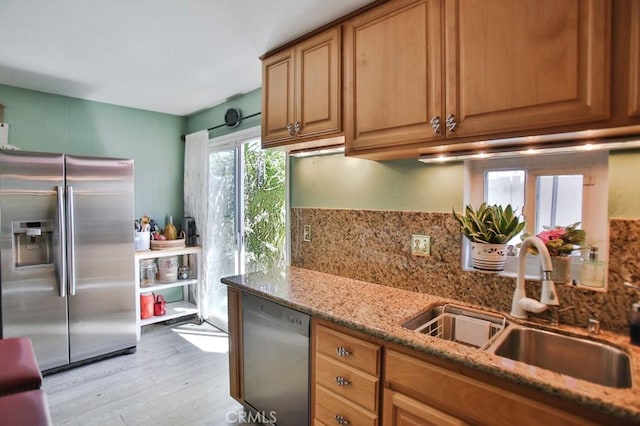 4502 Bates Dr, Yorba Linda, CA 92886 - kitchen featuring appliances with stainless steel finishes, a sink, light wood-type flooring, decorative backsplash, and light stone countertops