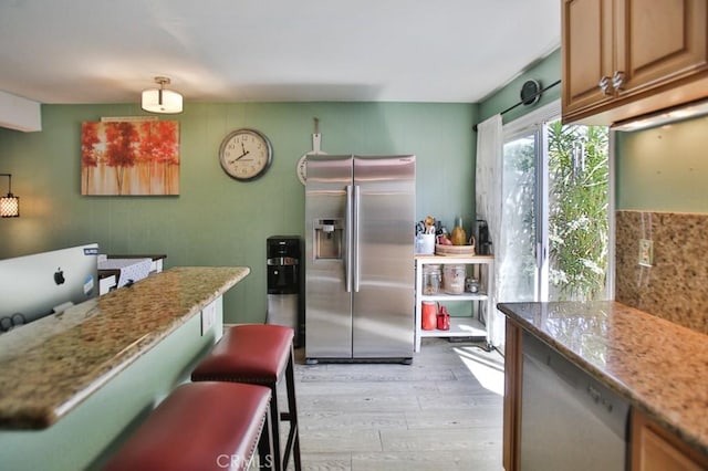 4502 Bates Dr, Yorba Linda, CA 92886 - kitchen with stainless steel fridge, light wood finished floors, light stone counters, and a kitchen breakfast bar