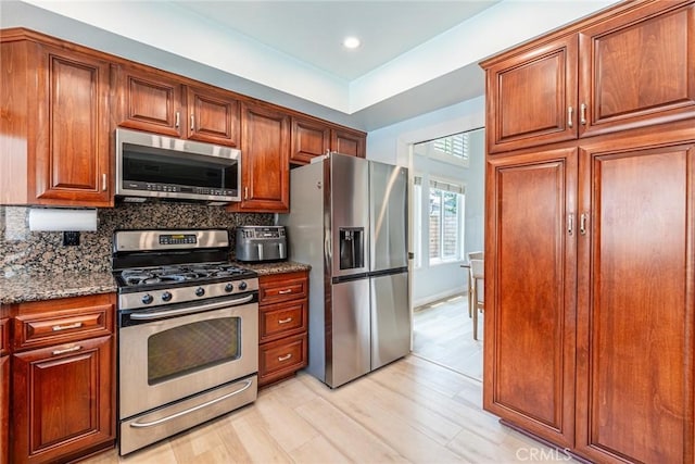 5940 Avenida Antigua, Yorba Linda, CA 92887 - kitchen with appliances with stainless steel finishes, backsplash, dark stone countertops, light wood-style flooring, and recessed lighting
