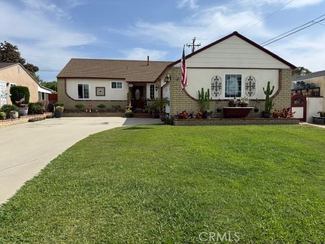 9912 Muroc St, Bellflower, CA 90706 - view of front of property with brick siding, a front lawn, and driveway