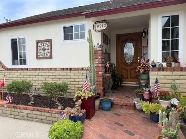 9912 Muroc St, Bellflower, CA 90706 - entrance to property with brick siding, roof with shingles, and stucco siding