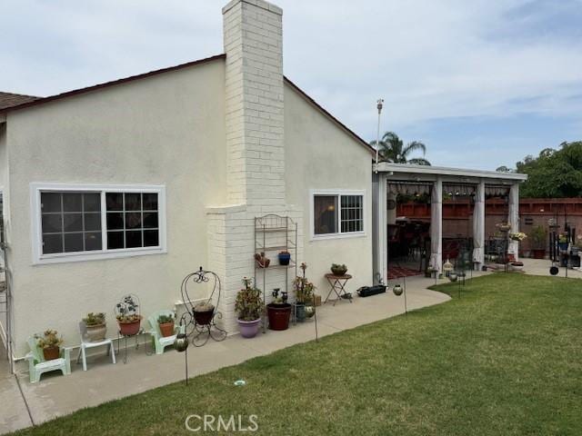 9912 Muroc St, Bellflower, CA 90706 - back of house featuring a patio, stucco siding, and a lawn