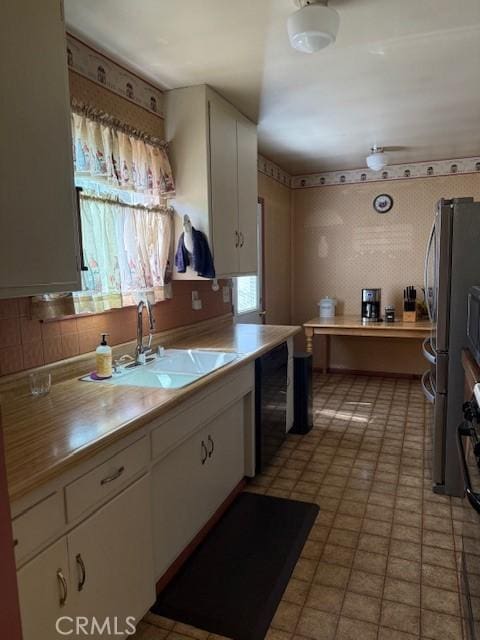 9912 Muroc St, Bellflower, CA 90706 - kitchen with a sink, white cabinets, light countertops, and freestanding refrigerator