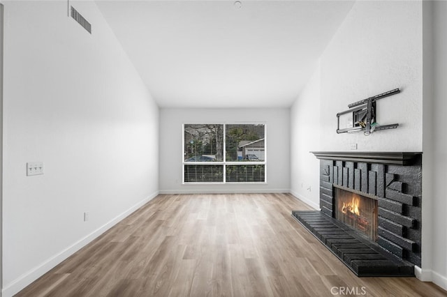 5453 Softwind Way, Agoura Hills, CA 91301 - unfurnished living room featuring a fireplace, wood finished floors, baseboards, and vaulted ceiling
