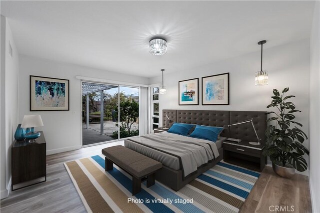 5453 Softwind Way, Agoura Hills, CA 91301 - bedroom with access to outside, wood finished floors, baseboards, and a chandelier