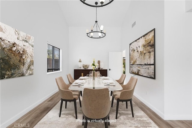 5453 Softwind Way, Agoura Hills, CA 91301 - dining space featuring high vaulted ceiling, a chandelier, wood finished floors, and baseboards