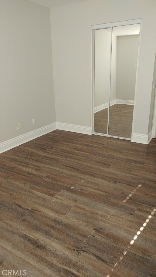 2400 Del Mar Way Unit 206, Corona, CA 92882 - unfurnished bedroom with baseboards, a closet, and dark wood finished floors