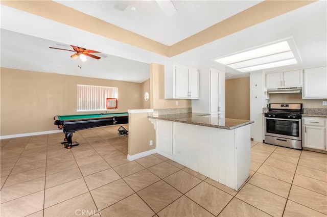 14317 Jicarilla Rd, Apple Valley, CA 92307 - kitchen featuring stainless steel range with gas cooktop, ceiling fan, under cabinet range hood, light tile patterned floors, and white cabinetry
