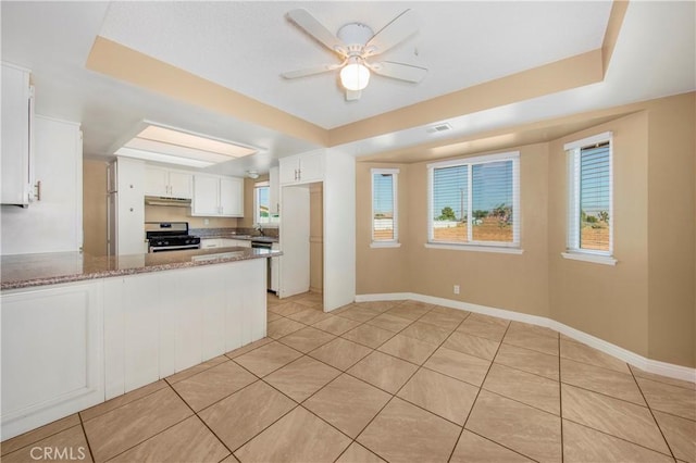 14317 Jicarilla Rd, Apple Valley, CA 92307 - kitchen featuring gas range, light tile patterned floors, white cabinets, under cabinet range hood, and a peninsula