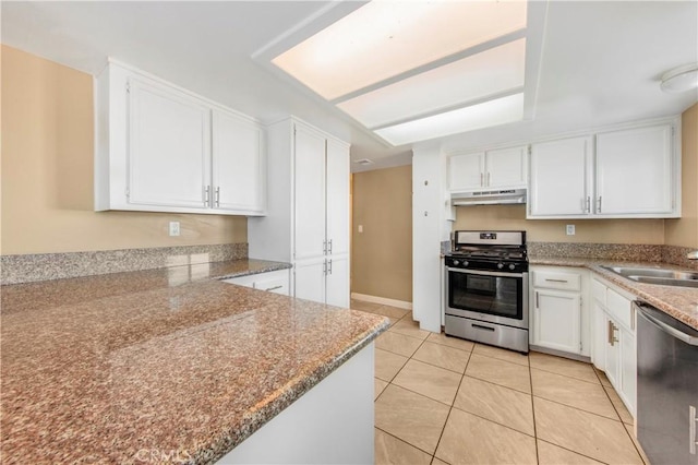 14317 Jicarilla Rd, Apple Valley, CA 92307 - kitchen with appliances with stainless steel finishes, under cabinet range hood, white cabinets, a sink, and light tile patterned flooring