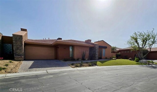 50135 Camino Privado Ln, Quinta, CA 92253 - view of front of house featuring an attached garage, decorative driveway, stucco siding, and a front yard