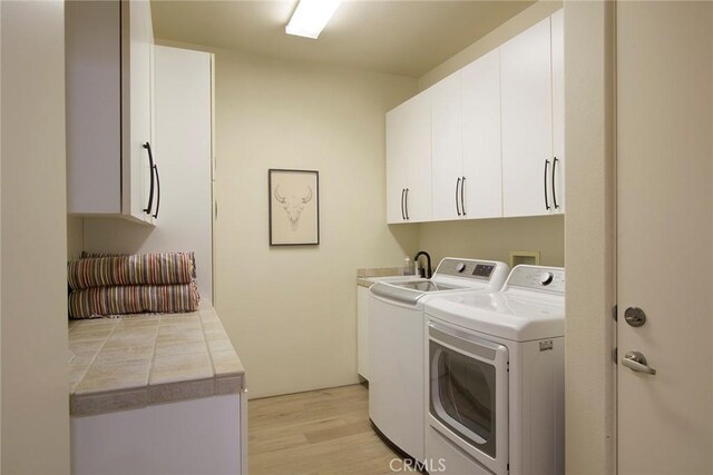 50135 Camino Privado Ln, Quinta, CA 92253 - laundry room featuring cabinet space, washer and clothes dryer, and light wood-type flooring