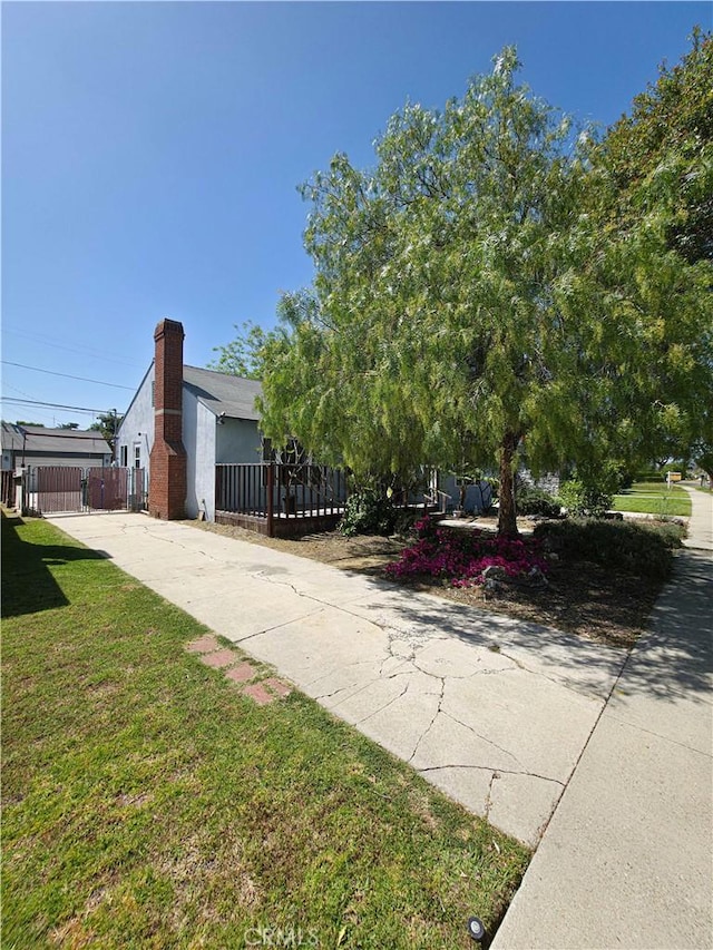 3817 Somerset Dr, Los Angeles, CA 90008 - view of property exterior with driveway, a chimney, and a gate