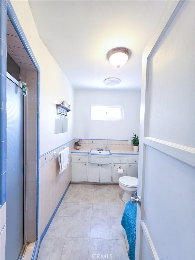 3817 Somerset Dr, Los Angeles, CA 90008 - bathroom with a stall shower, vanity, toilet, tile patterned flooring, and wainscoting
