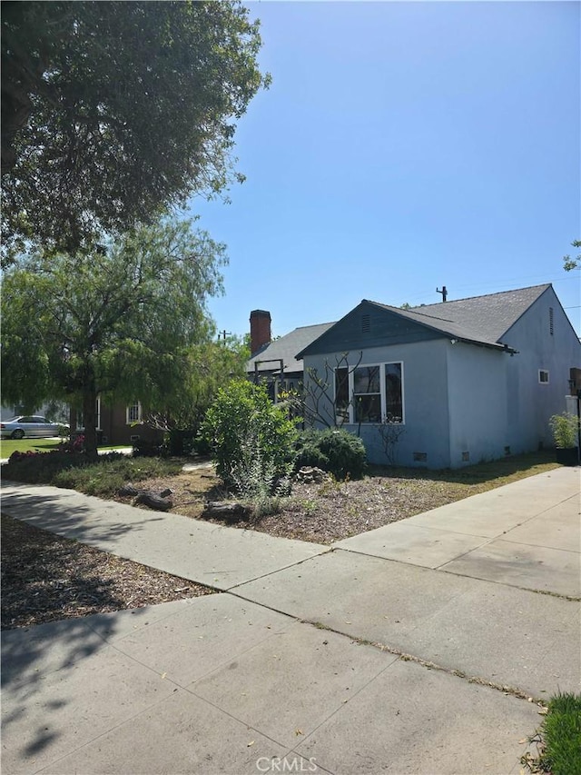 3817 Somerset Dr, Los Angeles, CA 90008 - view of front of house featuring a chimney, roof with shingles, stucco siding, and driveway