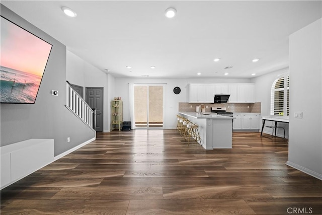 16007 Dexter St, Chino, CA 91708 - kitchen with stainless steel stove, black microwave, light countertops, white cabinetry, and dark wood-type flooring