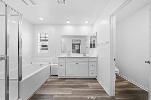 16007 Dexter St, Chino, CA 91708 - bathroom with double vanity, a garden tub, toilet, a stall shower, and wood finished floors