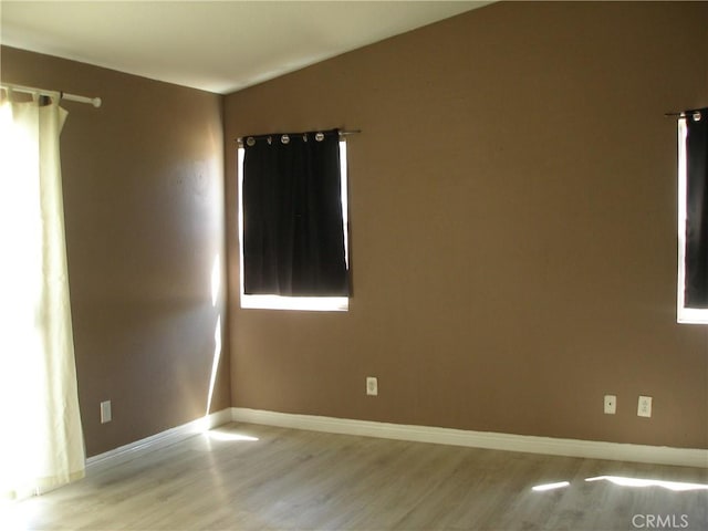 12975 Stanford Dr, Victorville, CA 92392 - spare room featuring light wood-type flooring, baseboards, and lofted ceiling