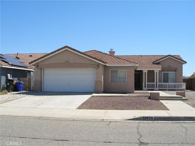 12975 Stanford Dr, Victorville, CA 92392 - ranch-style home with stucco siding, a tiled roof, an attached garage, and driveway