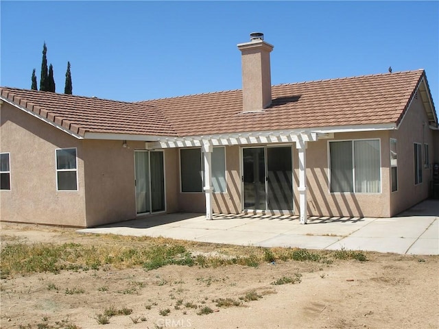 12975 Stanford Dr, Victorville, CA 92392 - rear view of house with a chimney, stucco siding, a patio area, and a tiled roof