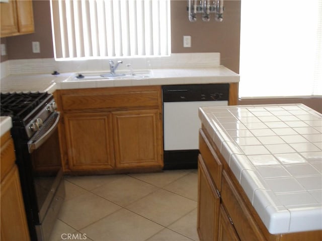 12975 Stanford Dr, Victorville, CA 92392 - kitchen with dishwasher, stainless steel gas stove, a sink, tile countertops, and brown cabinetry