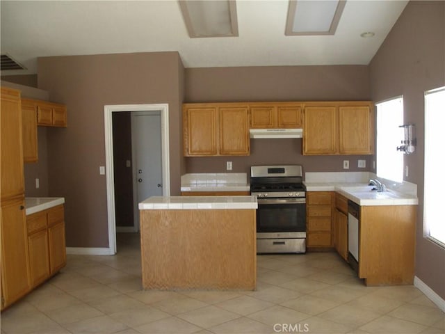 12975 Stanford Dr, Victorville, CA 92392 - kitchen with stainless steel gas stove, under cabinet range hood, a kitchen island, a sink, and tile counters